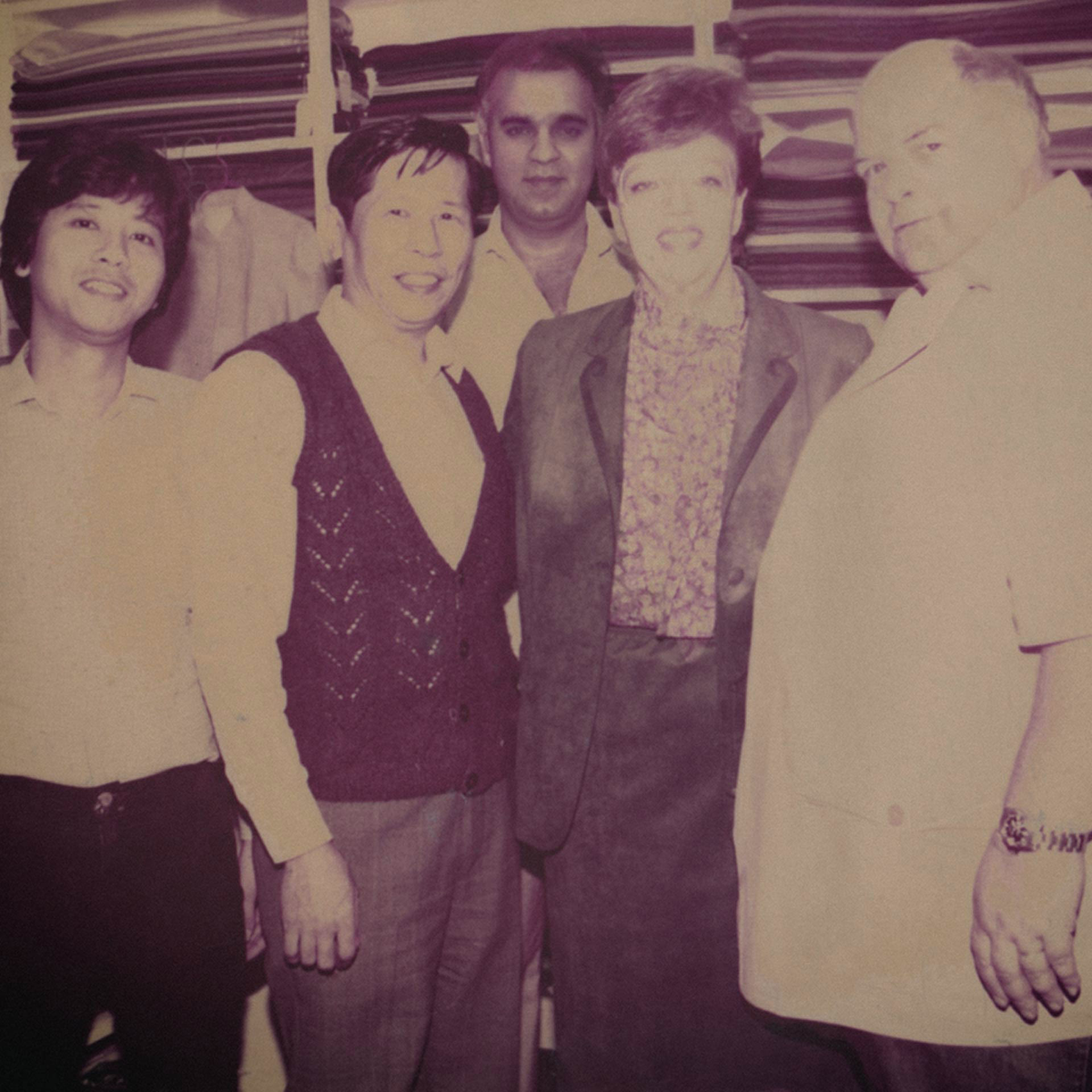 An old photo of Harry with his customers and tailors